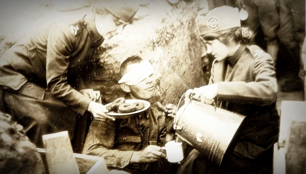 Волонтеры угощают американского солдата пончиками во времена Первой мировой войны.