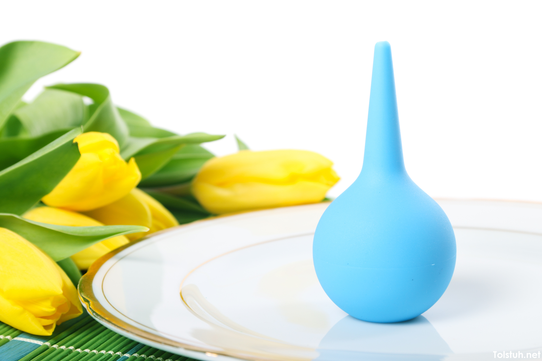 Blue enema on plate and tulips isolated on white background