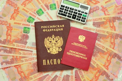 Pension certificate data sheet and calculator on the background of the Russian money