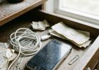 приоткрытый ящик письменного стола, внутри лежит старый смартфон с потертым корпусом