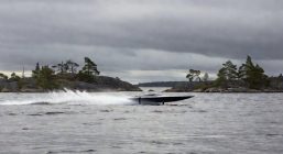 скоростное судно на подводных крыльях идёт по серо-стальной воде северного озера